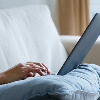 Woman type on notebook computer at home